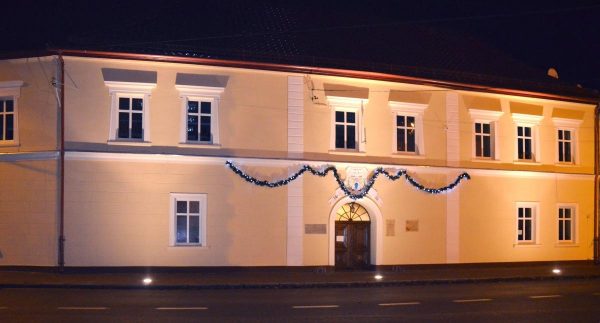 Miejska Biblioteka Publiczna w Jastrowiu po zmroku. Kamienny Dom z nowa elewacją i iluminacją zewnętrzną